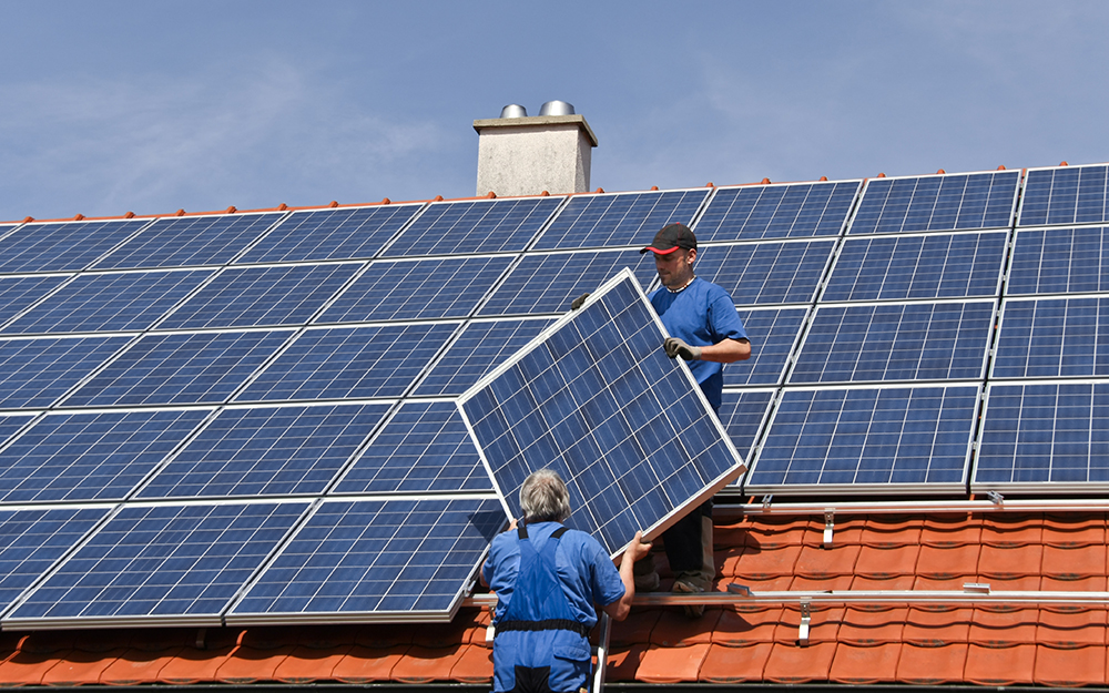 Contractors Mounting Solar Panels on a House.